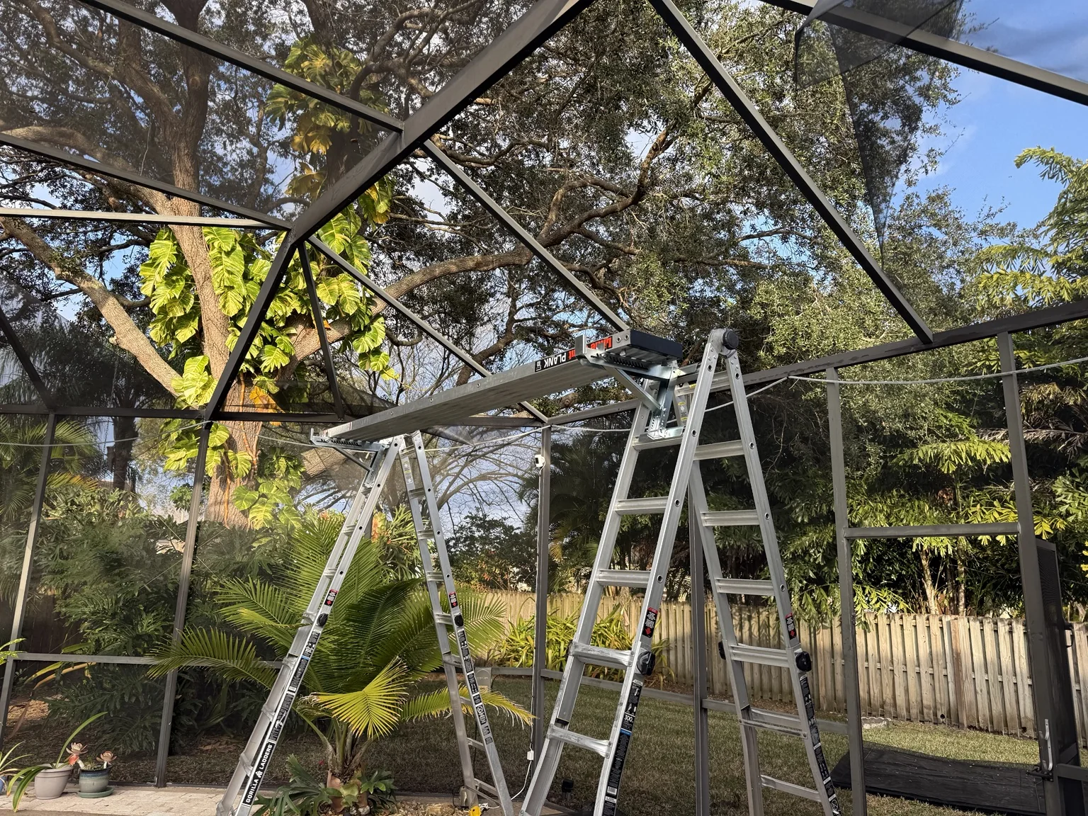 Installing new roof screen across the existing aluminum enclosure.
