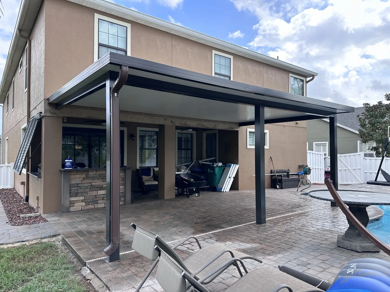 Insulated patio cover extending the usable outdoor living area beside the pool.