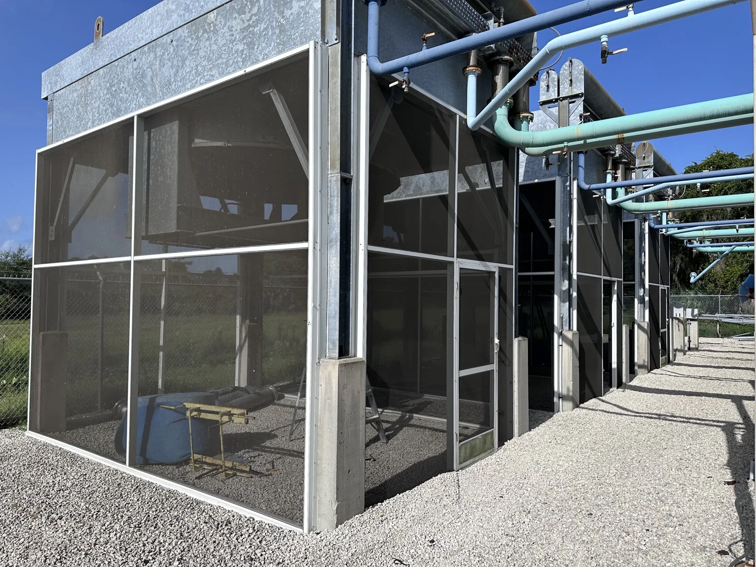 Custom screening built around industrial mechanical equipment while maintaining service access and ventilation.