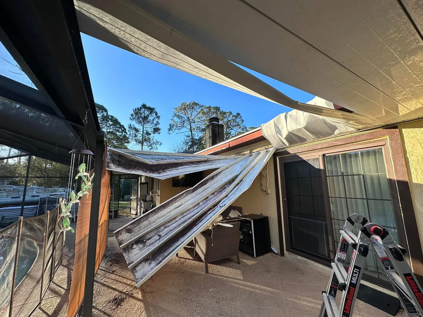 Storm-damaged roof after hurricane winds lifted and collapsed the existing panels.