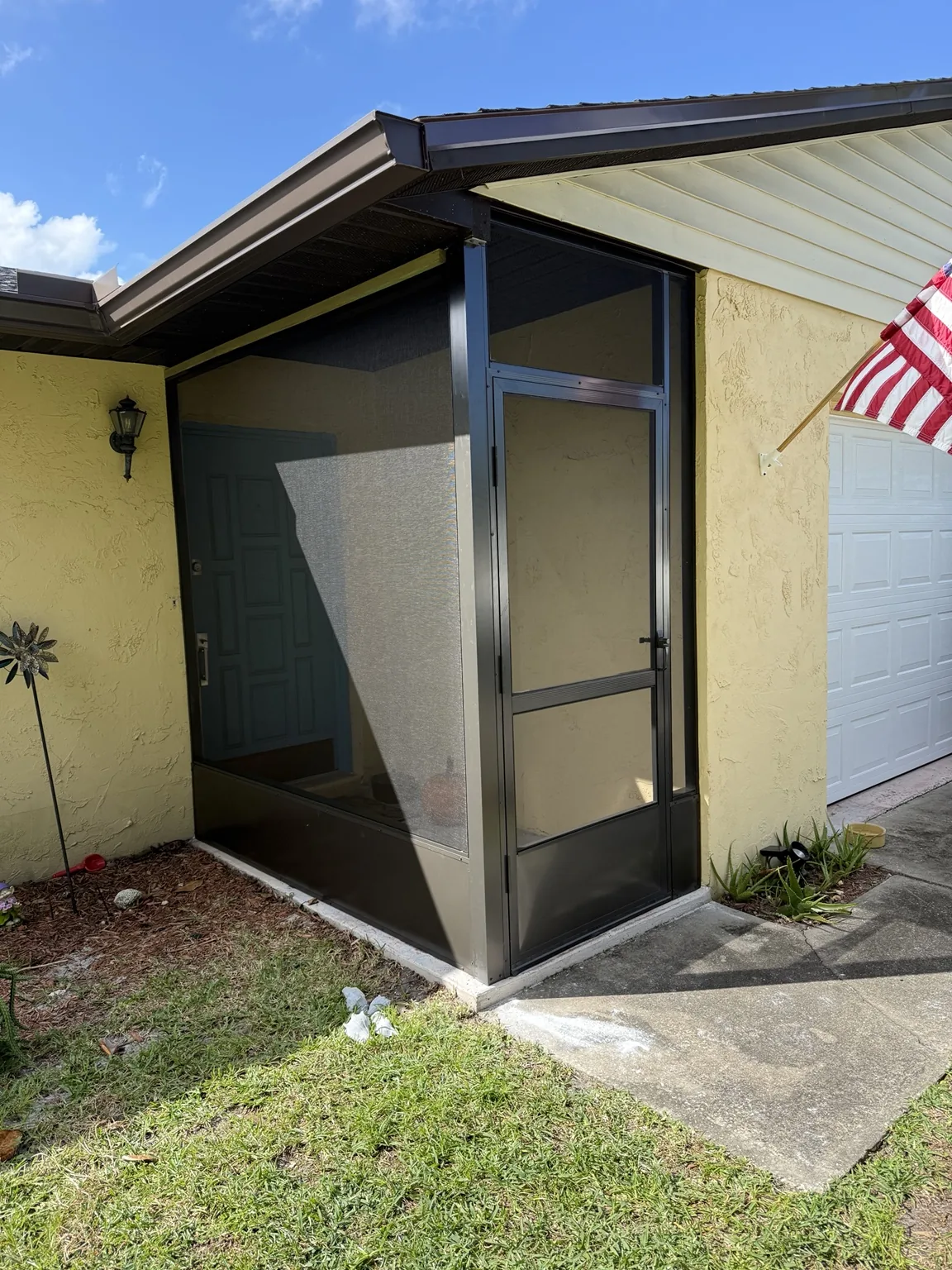 Custom framed front entry enclosure with integrated screen door.