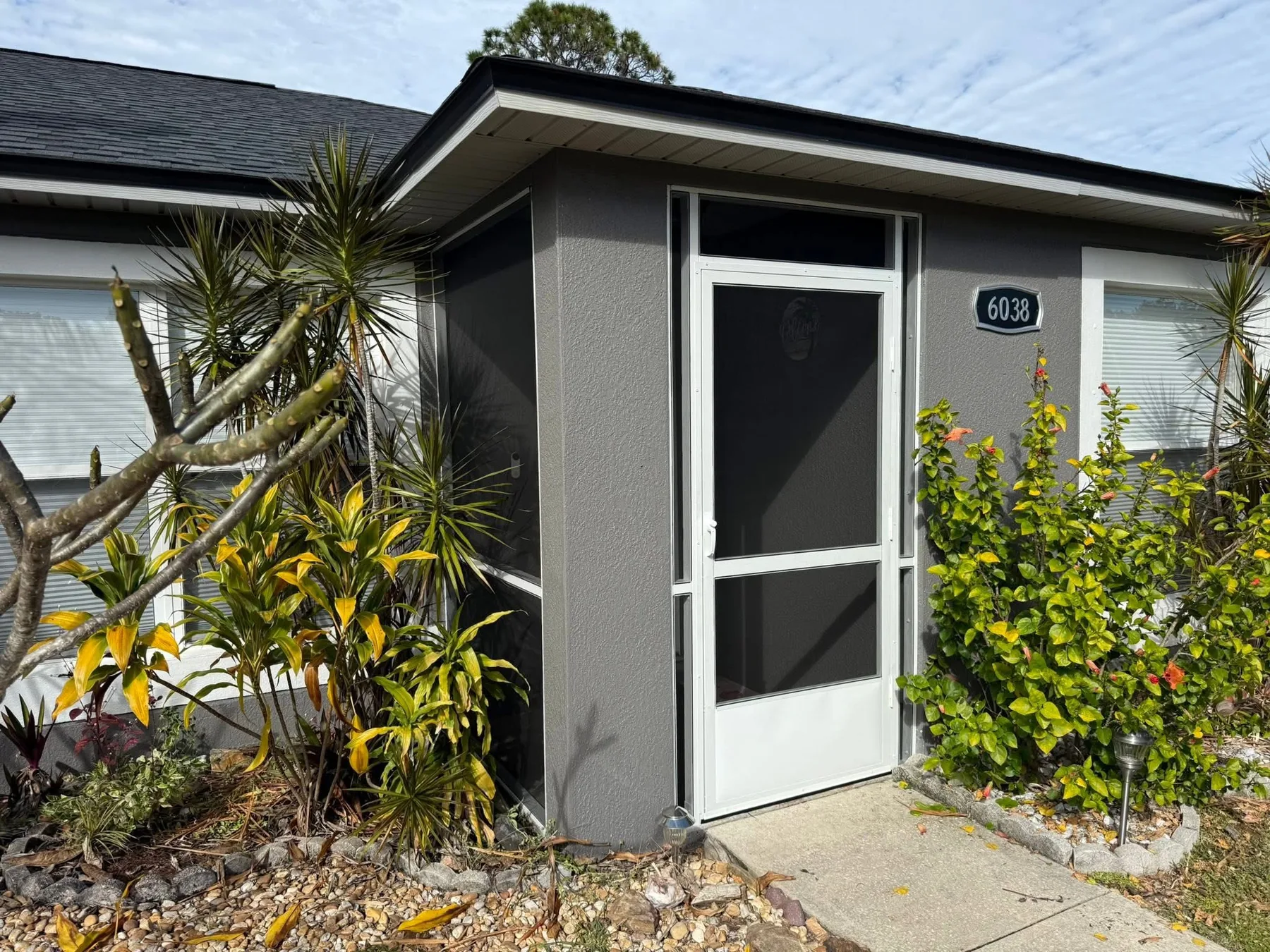 Screened front-entry vestibule integrated into the existing architecture.