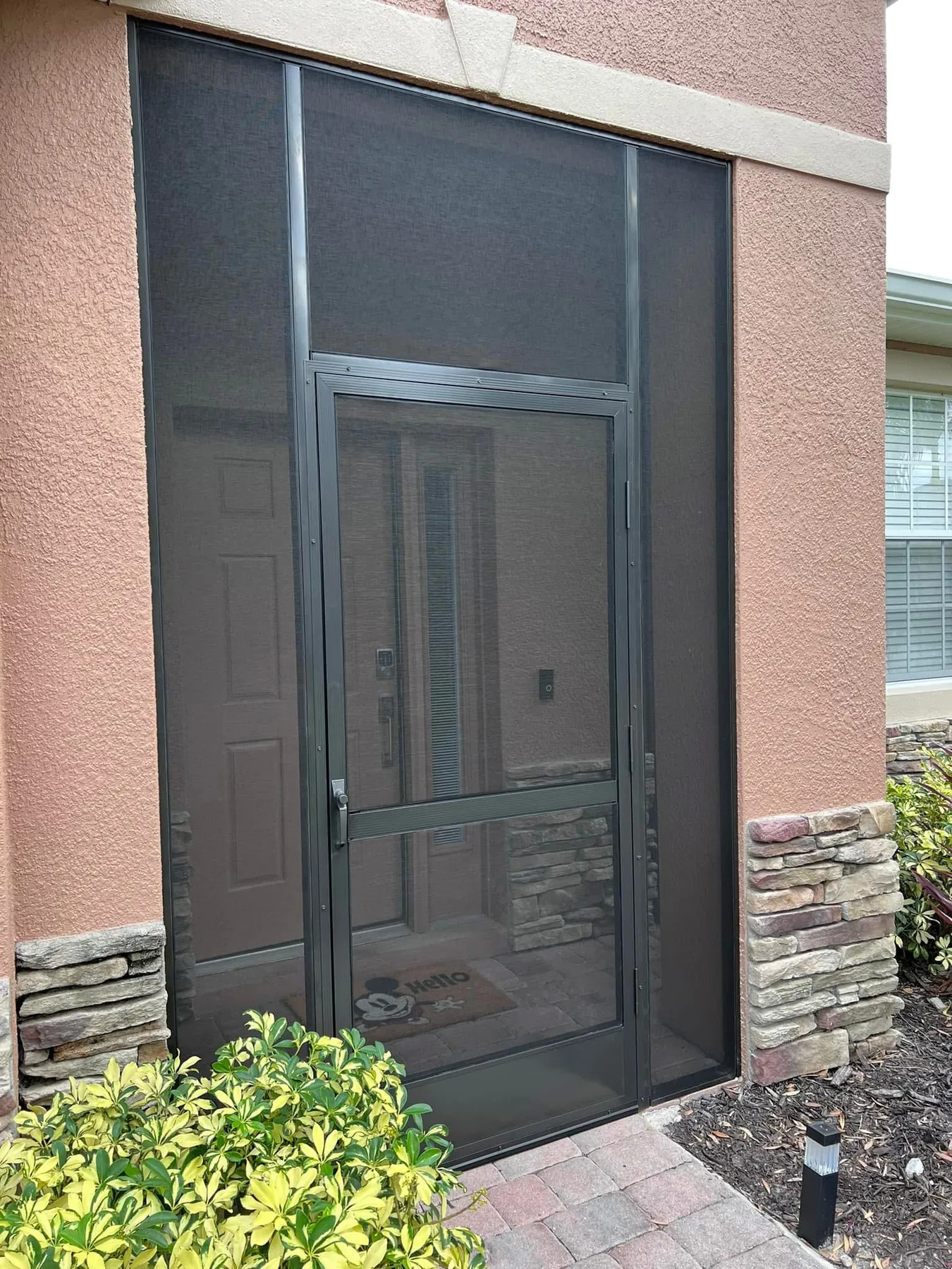Full-height custom entry screening with dark aluminum framing.